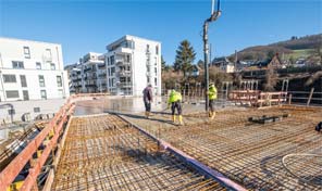 Auf einer Zenz Massivhaus Baustelle wird eine Betondecke gegossen 